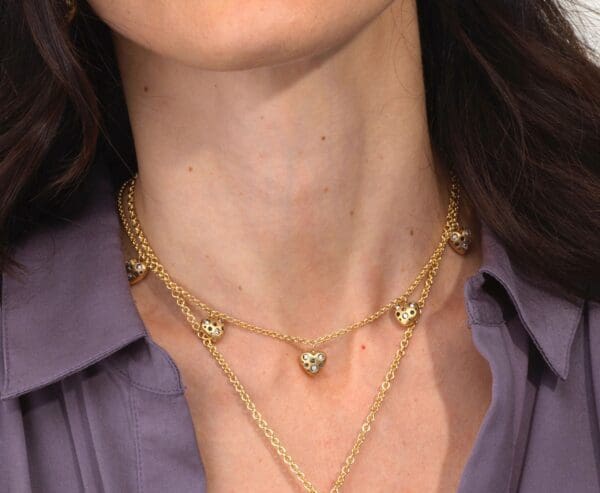 A woman wearing a necklace with hearts on it.
