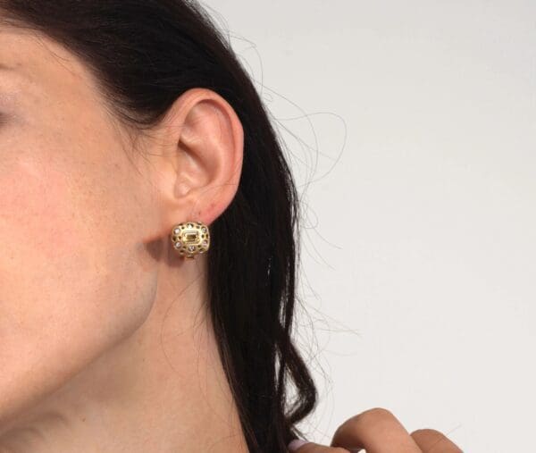 A woman wearing gold earrings and a black hair