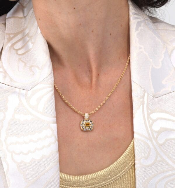 A woman wearing a necklace with an image of a face on it.