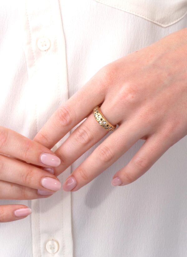 A woman is holding her wedding ring on the finger