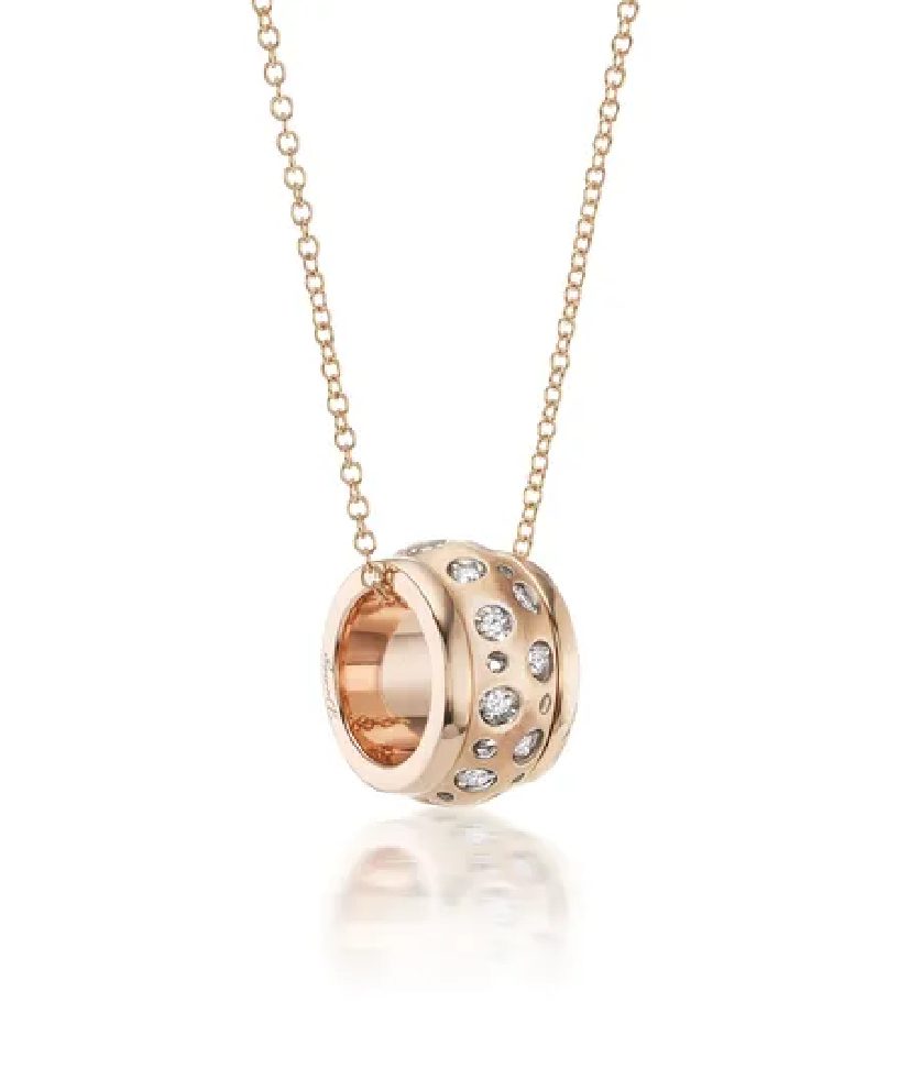A rose gold necklace with a diamond ring on it