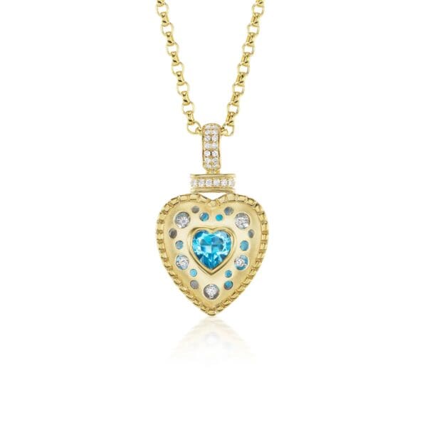 A gold necklace with a heart shaped blue stone.