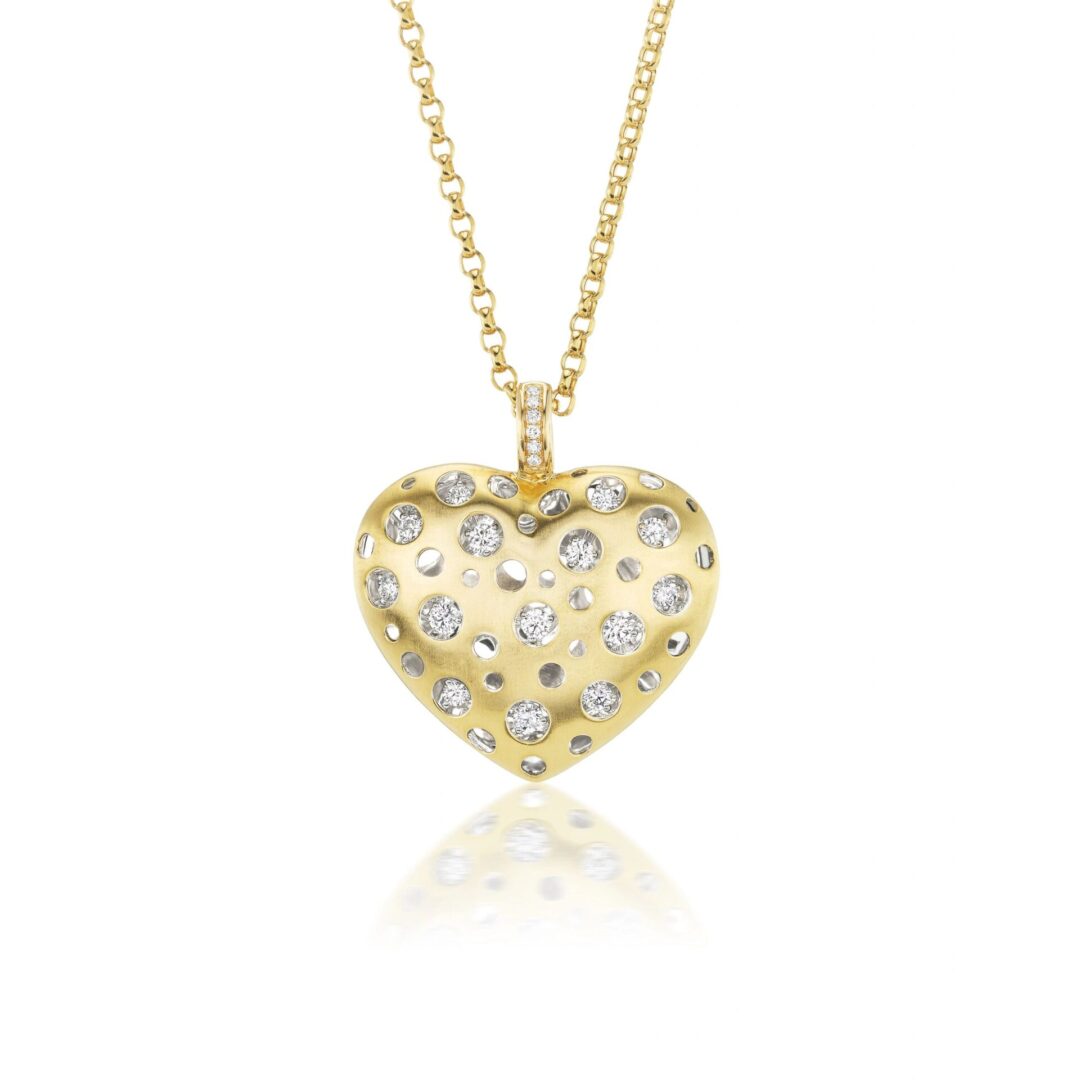A gold necklace with a heart shaped pendant.