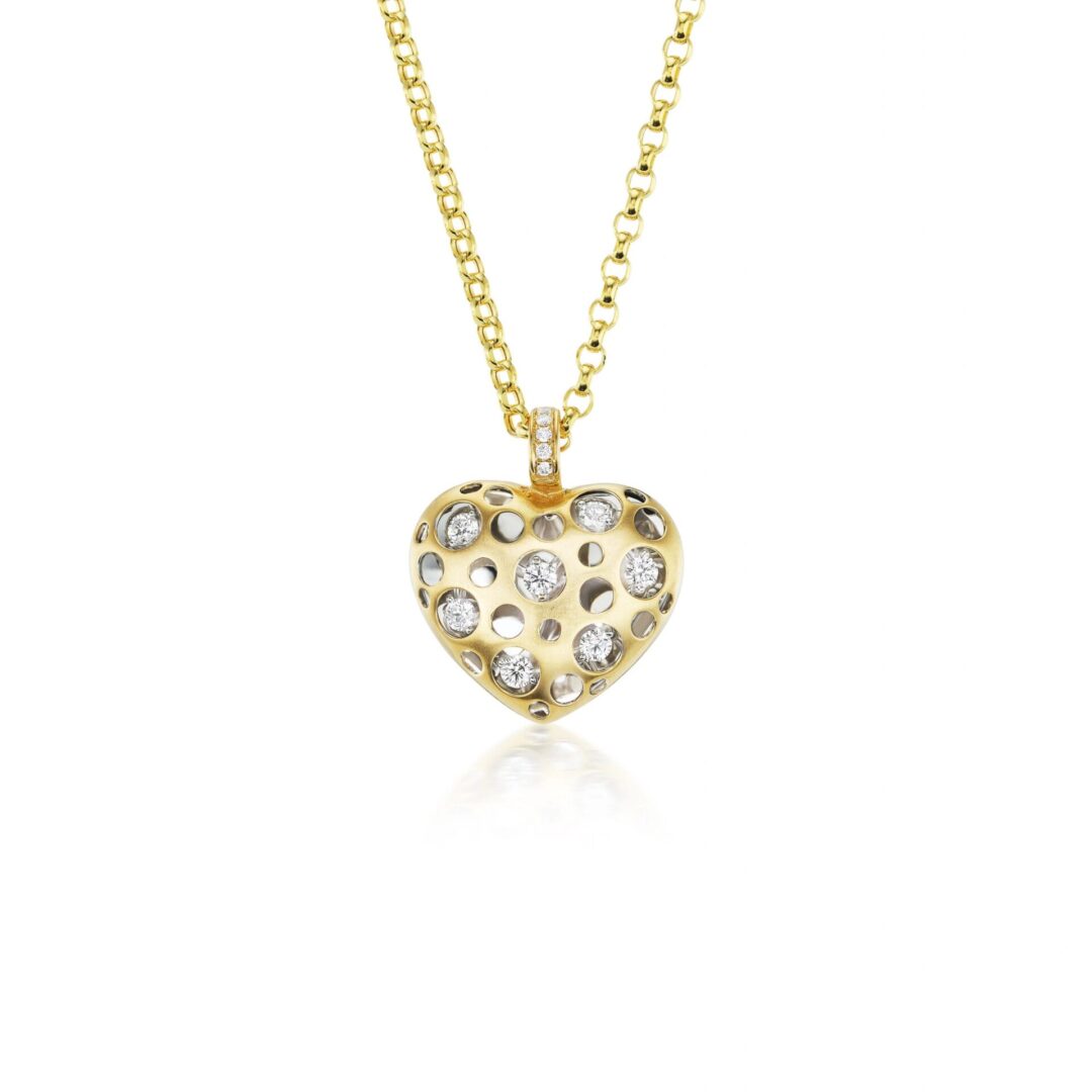 A gold necklace with a heart shaped pendant.