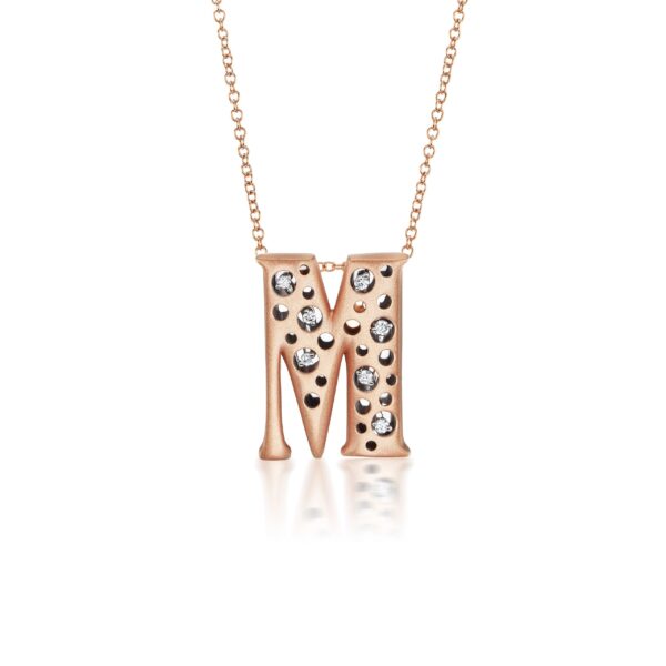 A rose gold necklace with the letter m