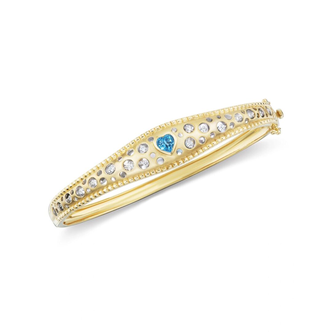 A gold bangle with blue and white stones.