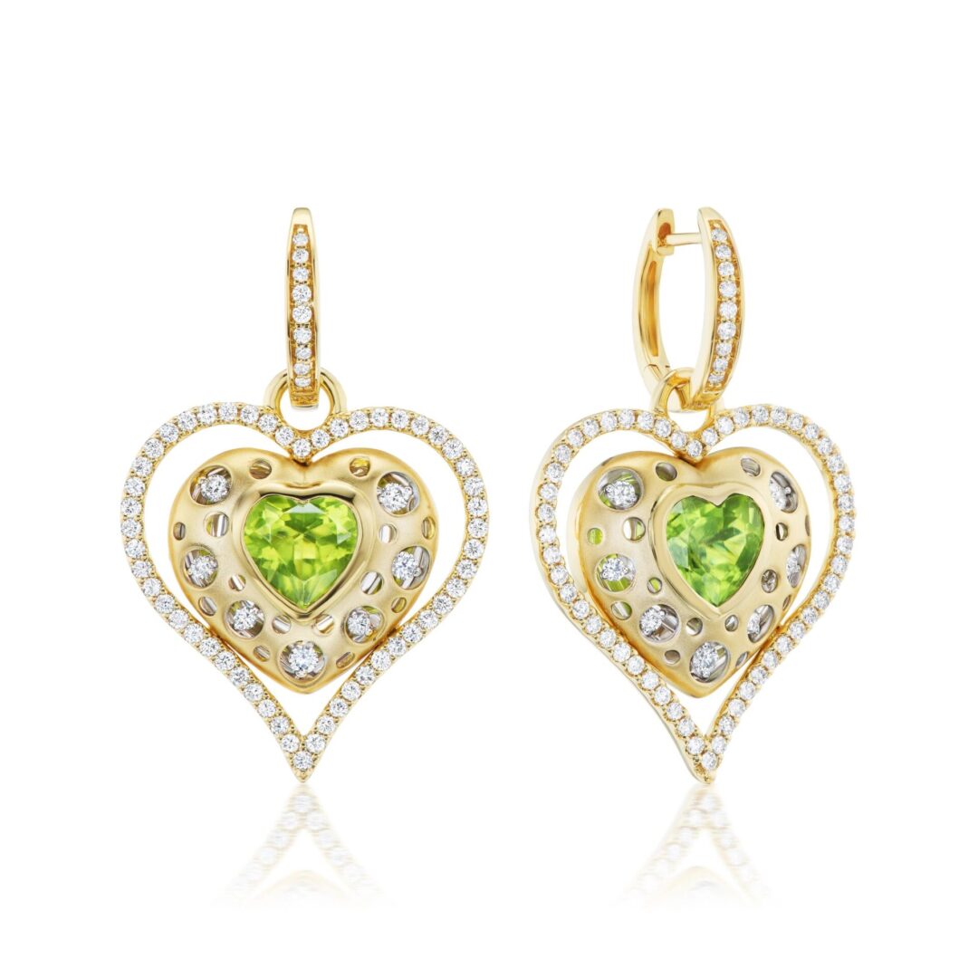 A pair of gold earrings with green and white stones.