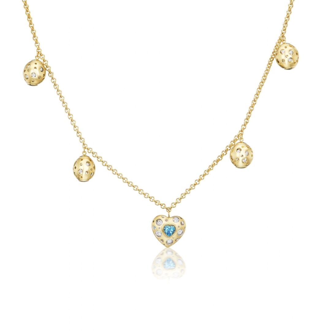 A gold necklace with five charms hanging from it.
