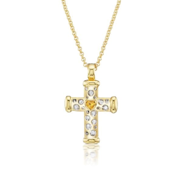 A gold cross with white and yellow stones.