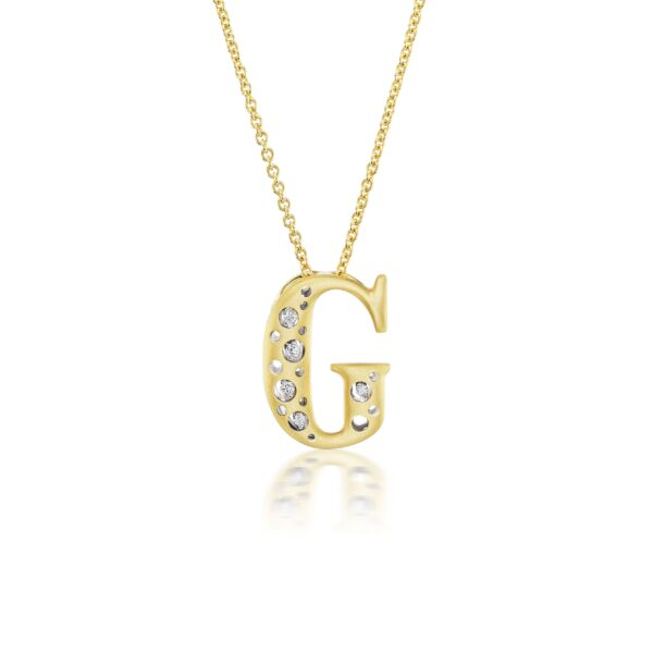 A gold necklace with the letter g