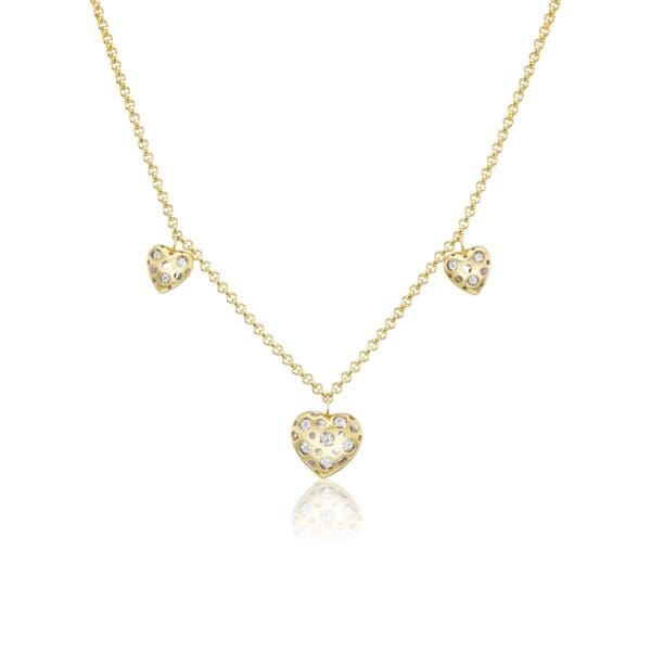 A gold necklace with three hearts on it