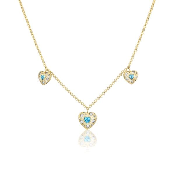A gold necklace with three blue hearts on it.