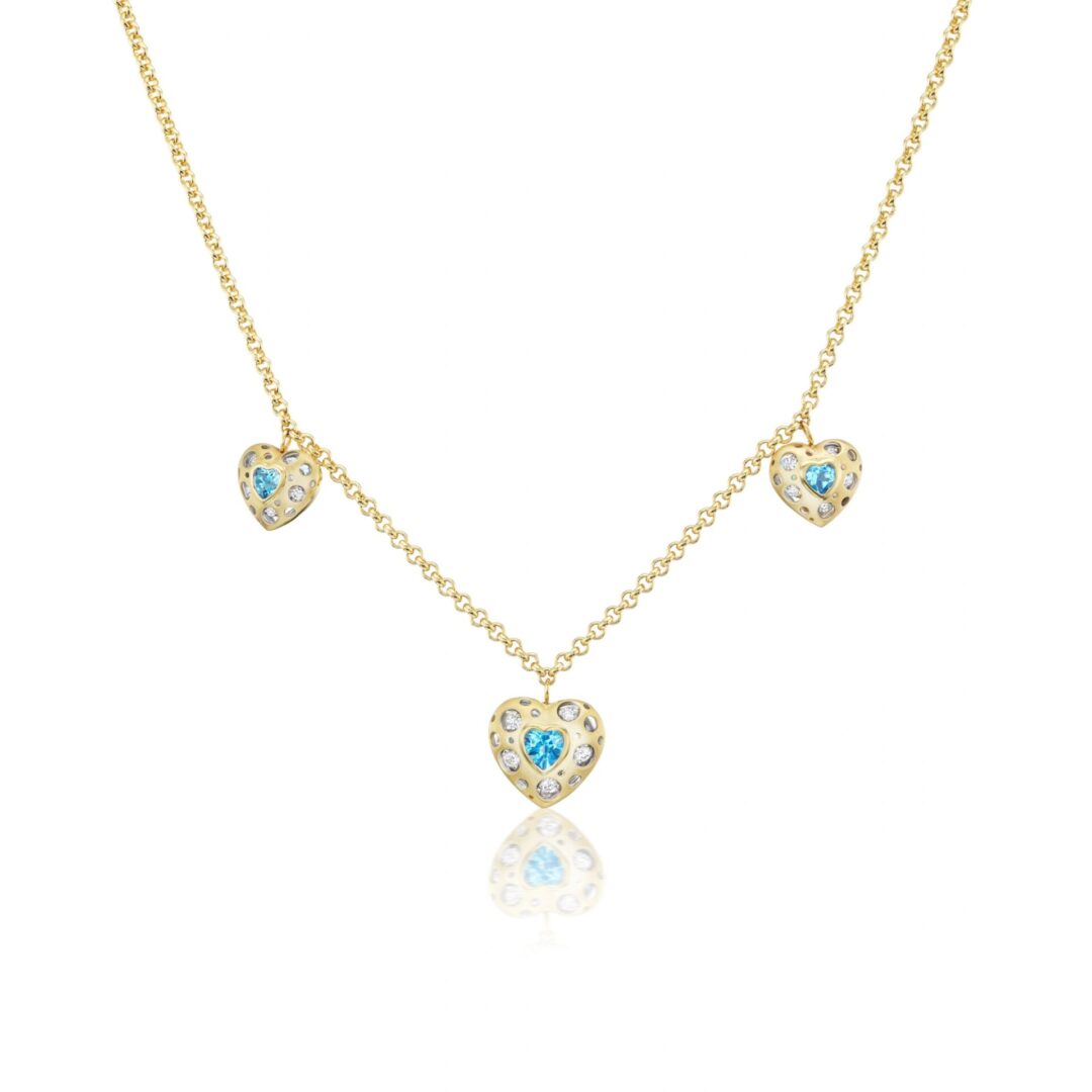 A gold necklace with three blue hearts on it.