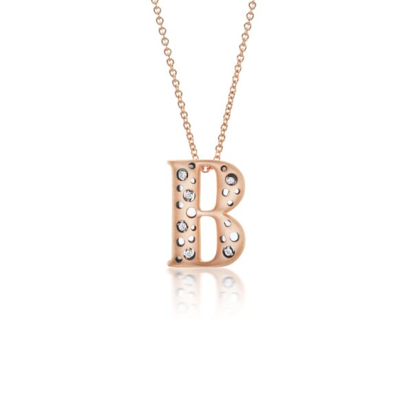 A rose gold necklace with the letter b in front of it.
