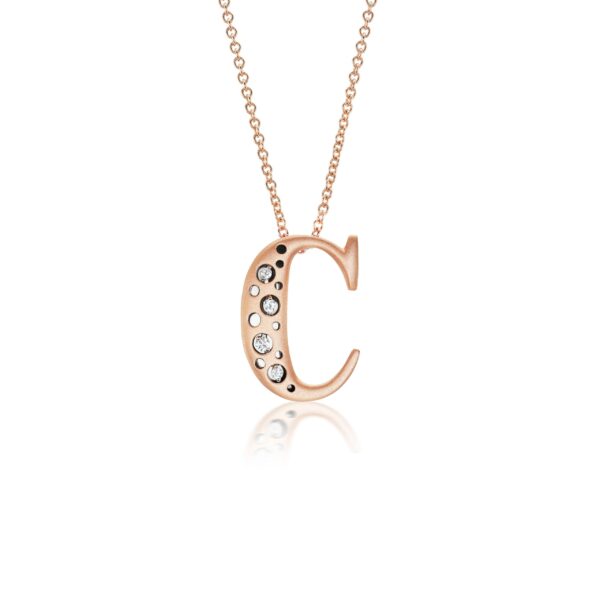 A rose gold necklace with a letter c on it