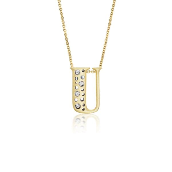 A gold necklace with a letter u on it