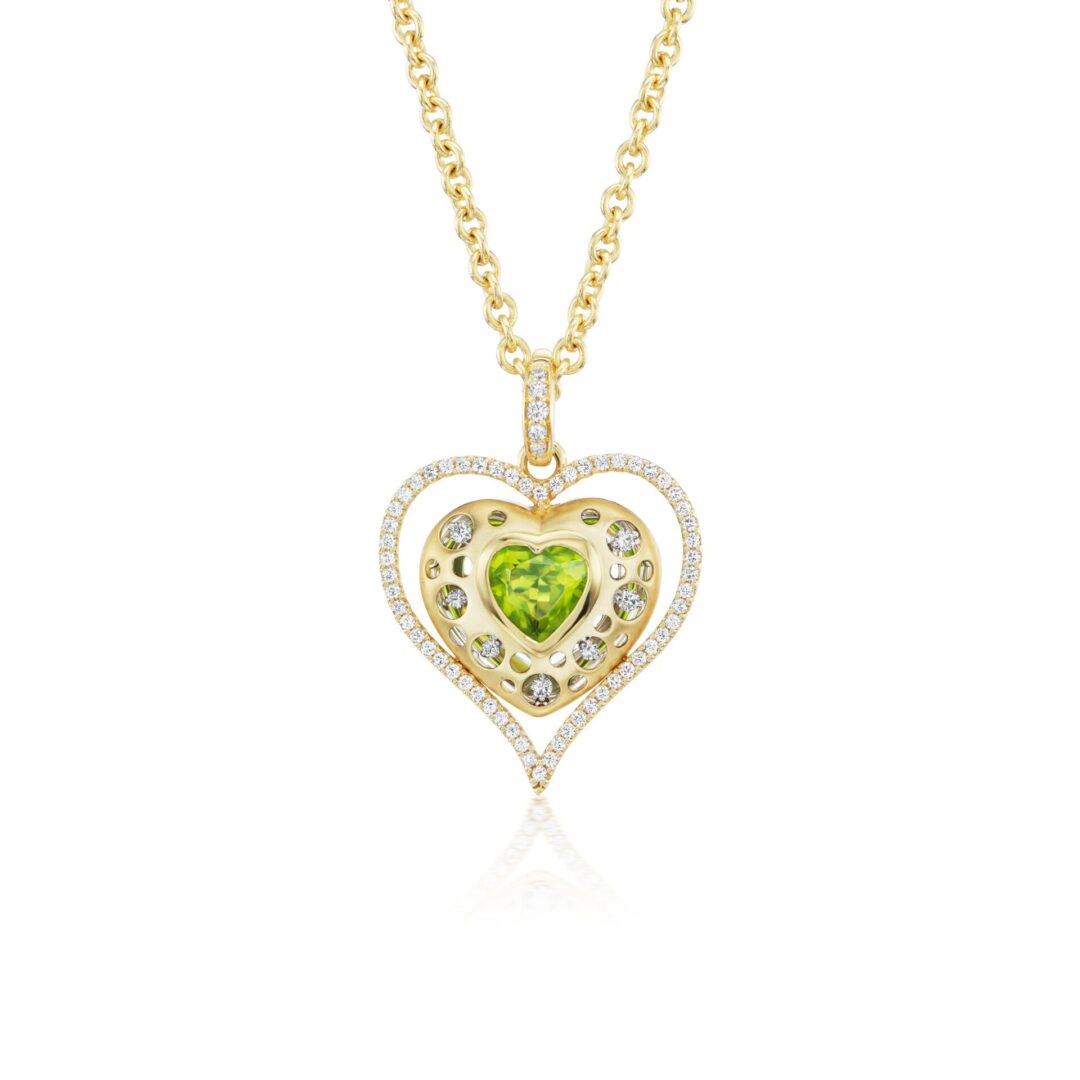 A gold necklace with a heart shaped stone.