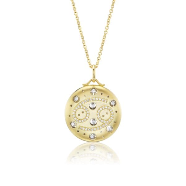 A gold necklace with a round pendant and diamonds.
