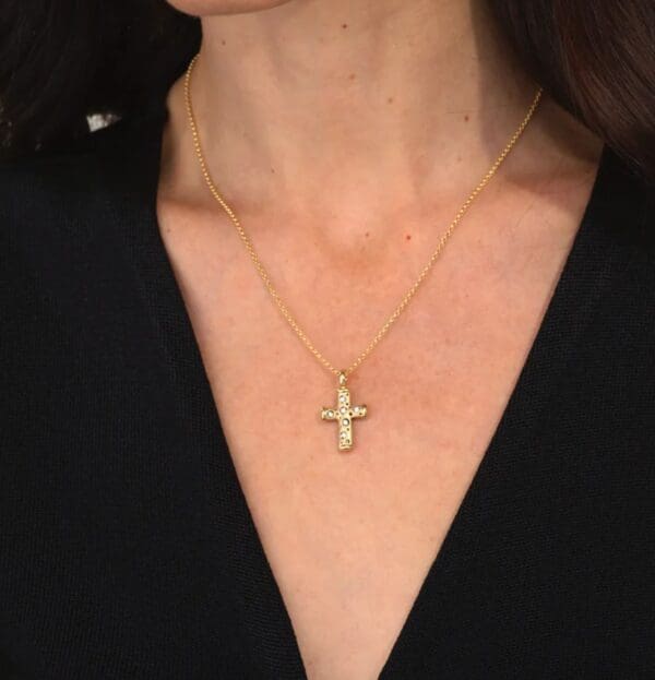 A woman wearing a necklace with a cross on it.