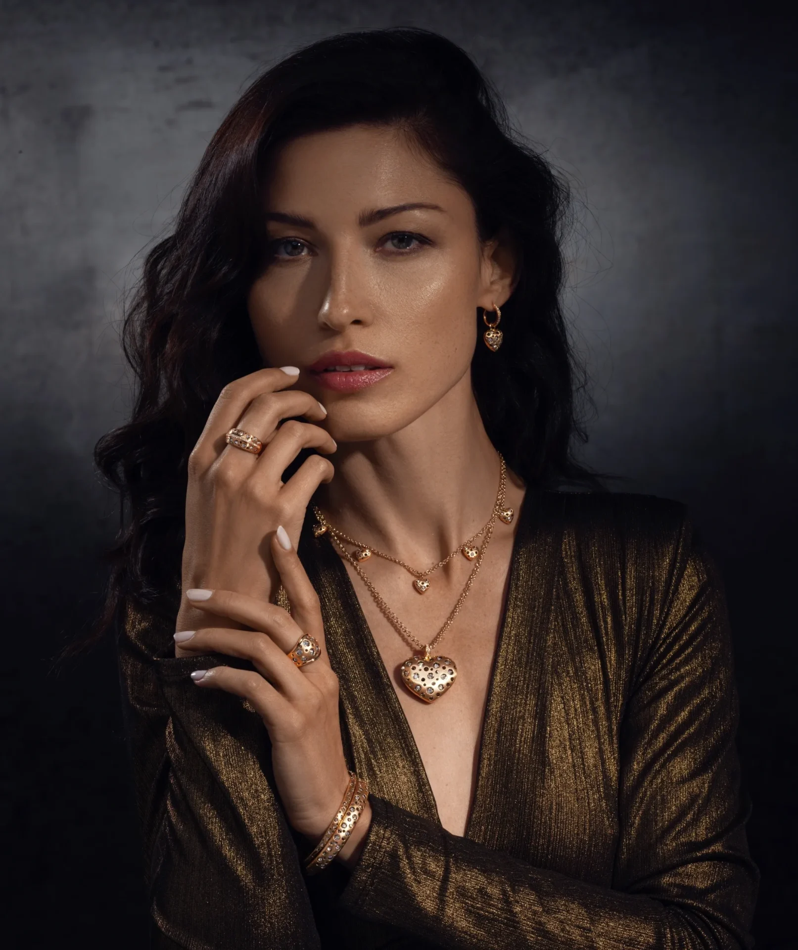 A woman with long hair and wearing gold jewelry.