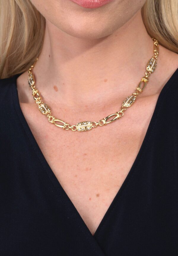 A woman wearing a gold chain necklace.