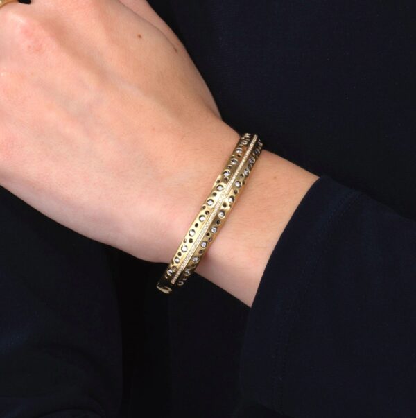 A woman wearing a gold bracelet with a black shirt